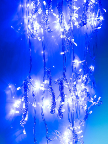 multicolored garland with small led bulbs on a dark background - Foto, Imagen