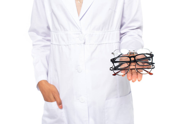 Cropped view of african american doctor holding eyeglasses isolated on white  - Photo, Image