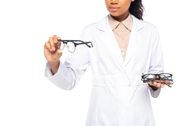 Cropped view of african american doctor holding eyeglasses in hands isolated on white  - Foto, Imagen