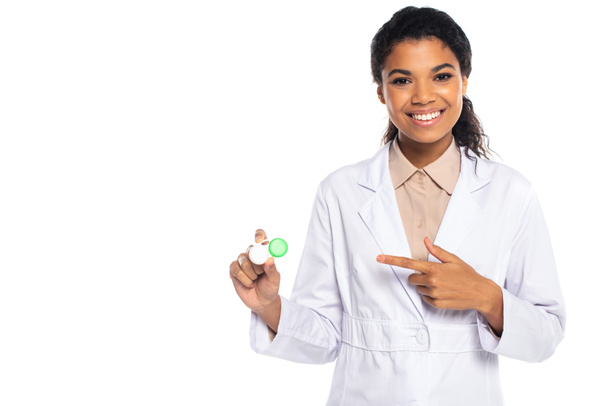 Young african american ophthalmologist pointing at container with contact lenses isolated on white  - Photo, Image