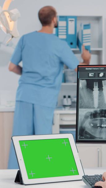 ortodontista utilizzando schermo verde orizzontale su tablet - Foto, immagini