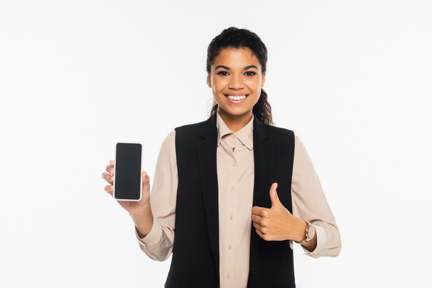 Sorridente donna d'affari afroamericana mostrando come e tenendo smartphone con schermo bianco isolato su bianco  - Foto, immagini
