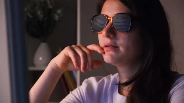 A woman in perforated glasses looks at the computer screen. - Footage, Video