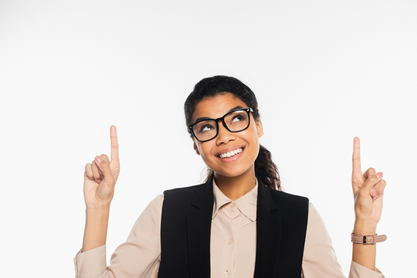 Allegro afroamericano donna d'affari in occhiali puntando con le dita isolate su bianco  - Foto, immagini