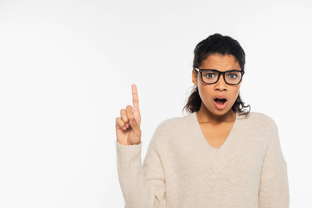 Inquiète femme afro-américaine aux lunettes pointant du doigt isolé sur blanc - Photo, image