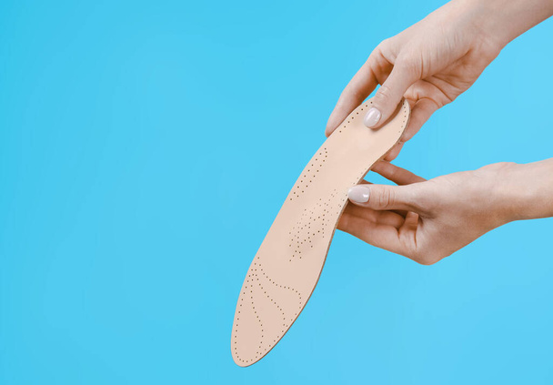 Orthopedic insole isolated on a blue background. Medical insoles. Treatment and prevention of flat feet and foot diseases. Foot care, feet comfort. Wear comfortable shoes. Flat Feet Correction - 写真・画像