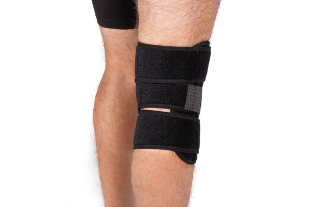 Knee Support Brace on leg isolated on white background. Orthopedic Anatomic. Braces for knee fixation, injuries and pain. Knee Joint Bandage Sleeve. Elastic Sports - Zdjęcie, obraz