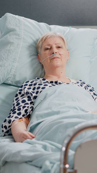 Portrait of sick patient laying in hospital ward bed - Photo, Image