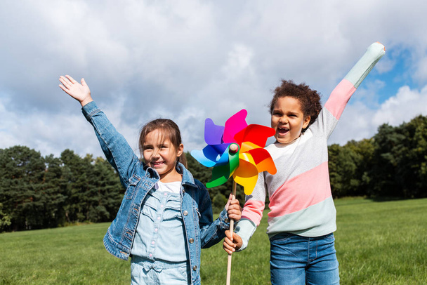 happy girls with pinwheel having fun at park - Foto, Imagem