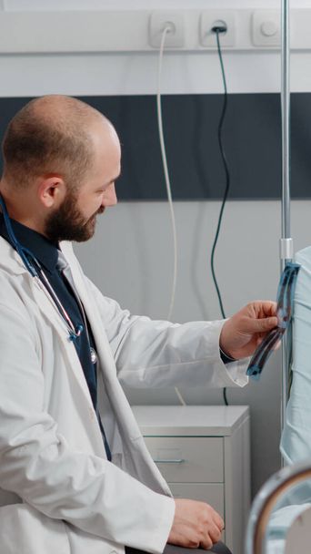 Lekarz i stary pacjent analizujący radiografię na potrzeby opieki zdrowotnej - Zdjęcie, obraz