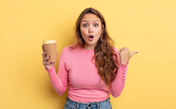 hispanic pretty woman looking astonished in disbelief. take away coffee concept - Foto, immagini