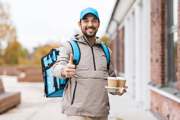 happy delivery man with thermal bag and coffee - Foto, Imagem
