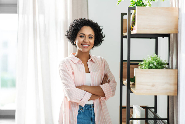 happy smiling woman standing at shelf at home - Foto, Imagen
