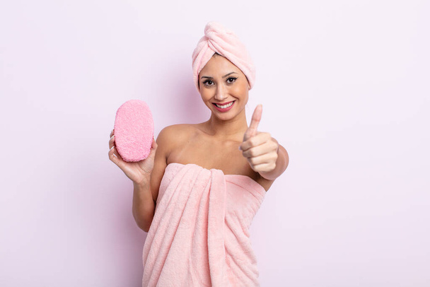 asiatic pretty woman feeling proud,smiling positively with thumbs up. bathrobe and sponge concept - Valokuva, kuva