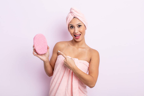 asiatic pretty woman looking excited and surprised pointing to the side. bathrobe and sponge concept - Zdjęcie, obraz