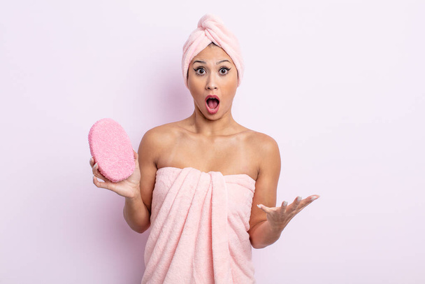 asiatic pretty woman amazed, shocked and astonished with an unbelievable surprise. bathrobe and sponge concept - 写真・画像
