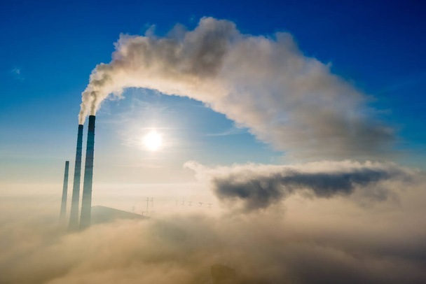 Vista aérea de tubulações altas da usina de carvão com fumaça preta que se move acima da atmosfera poluente no por do sol - Foto, Imagem