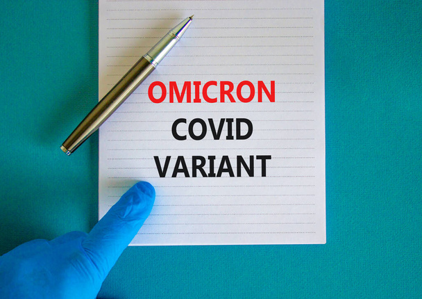 New covid-19 omicron variant strain symbol. Hand in blue glove with white note. Concept words Omicron covid variant. Metalic pen. Medical and COVID-19 omicron variant strain concept. Copy space. - Фото, зображення
