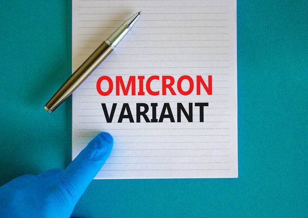 New covid-19 omicron variant strain symbol. Hand in blue glove with white note. Concept words Omicron variant. Metalic pen. Medical and COVID-19 omicron variant strain concept. Copy space. - Photo, Image