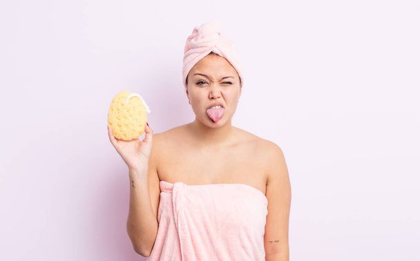 hispanic pretty woman feeling disgusted and irritated and tongue out. bathrobe and sponge concept - 写真・画像