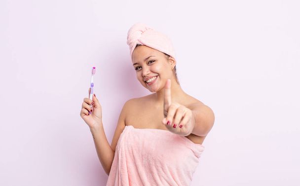 hispanic pretty woman smiling proudly and confidently making number one tooth brush concept - Valokuva, kuva