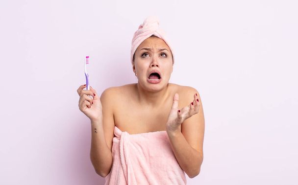 hispanic pretty woman looking desperate, frustrated and stressed tooth brush concept - Foto, imagen