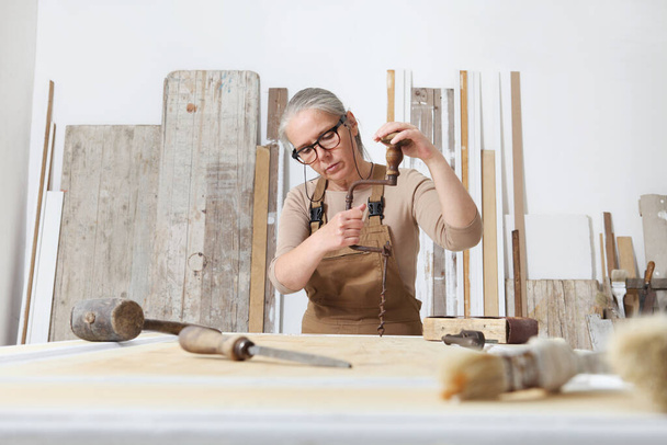 artesanía de madera, mujer carpintero artesanal trabaja madera con herramientas manuales antiguas en su taller, restauración, DIY y concepto de obras hechas a mano - Foto, Imagen