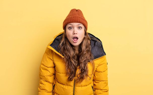 hispanic pretty woman looking very shocked or surprised. winter clothes - Foto, Imagem