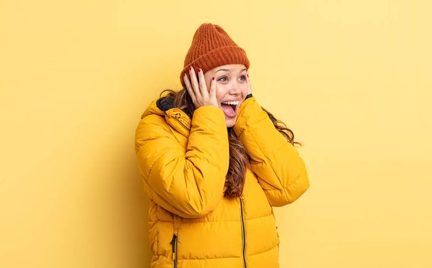 hispanic pretty woman feeling happy, excited and surprised. winter clothes - Foto, Imagem