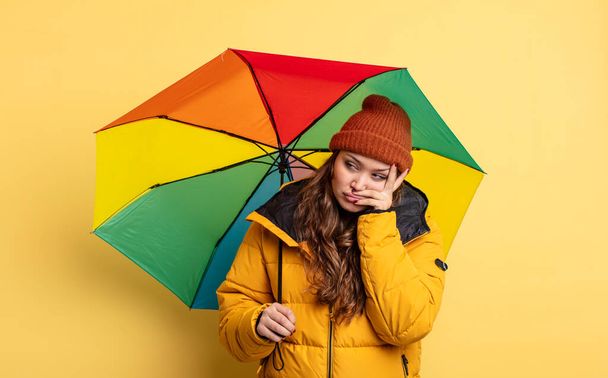hispanic pretty woman feeling bored, frustrated and sleepy after a tiresome. umbrella concept - 写真・画像