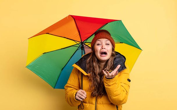 hispanic pretty woman looking desperate, frustrated and stressed. umbrella concept - Φωτογραφία, εικόνα