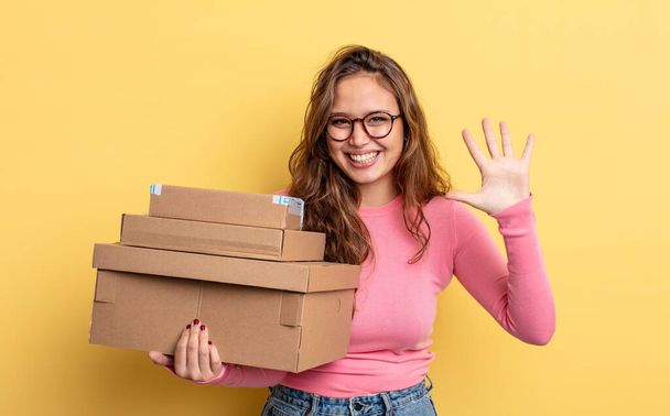 hispanic pretty woman smiling and looking friendly, showing number five. storage concept - Foto, Bild