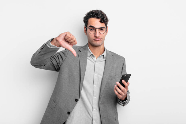 hispanic handsome man feeling cross,showing thumbs down. business and phone concept - Fotoğraf, Görsel