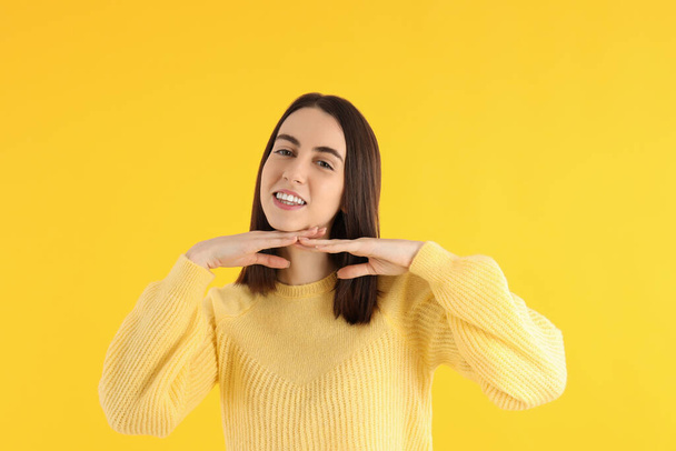 Привлекательная девушка в свитере на желтом фоне - Фото, изображение