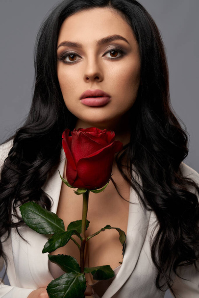 Stunning woman with red rose posing in studio  - Φωτογραφία, εικόνα
