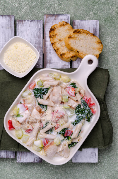 Traditionele pasta met gevogelte en groenten in een witte saus. Bovenaanzicht. Selectieve focus.  - Foto, afbeelding