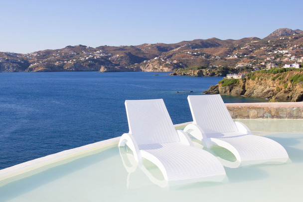 ギリシャの海の景色とプールで白い椅子 - 写真・画像