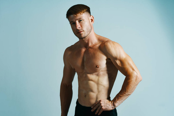 bodybuilder with muscular body posing press blue background - Foto, Bild