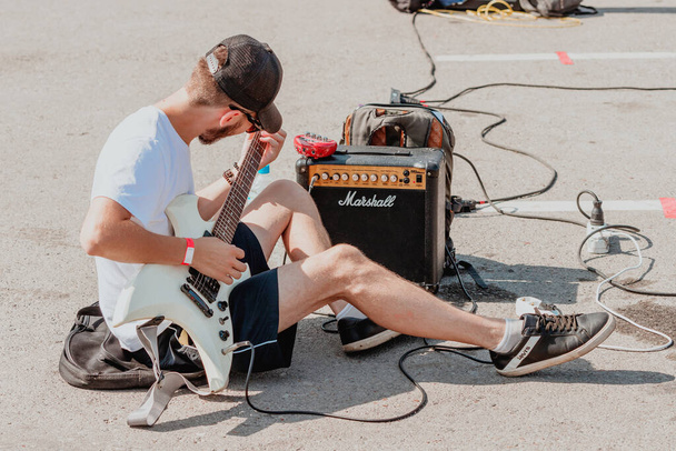 21. srpna 2021, Ufa, Rusko: Pouliční kytarista si před vystoupením naladí Marshallovu kytarovou zesilovačku. Kontrola zvuku a vybavení - Fotografie, Obrázek