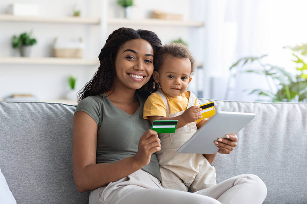 Online platby. Černá maminka a dítě pomocí digitální tablety a kreditní karty - Fotografie, Obrázek