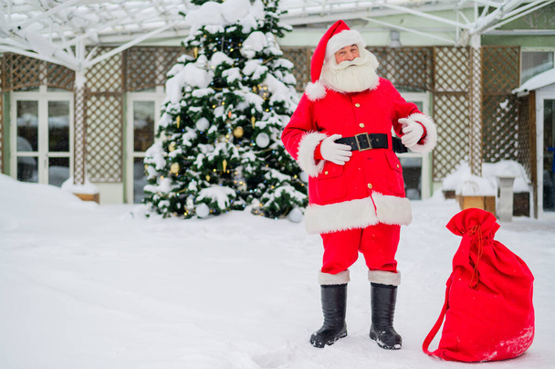 Santa claus wishes a merry christmas outdoors - 写真・画像