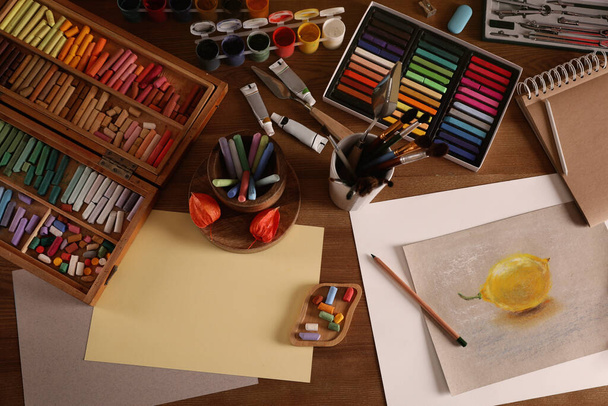 Artist's workplace with drawing, soft pastels and color pencils on table, flat lay - Photo, Image