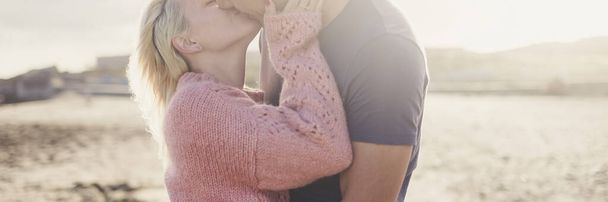 Pár szerelmes csók és ölelés romantika banner fejléc kompozíció. Napfény a háttérben. A fiatalok fogalma élvezik a kültéri kapcsolatokat - Fotó, kép