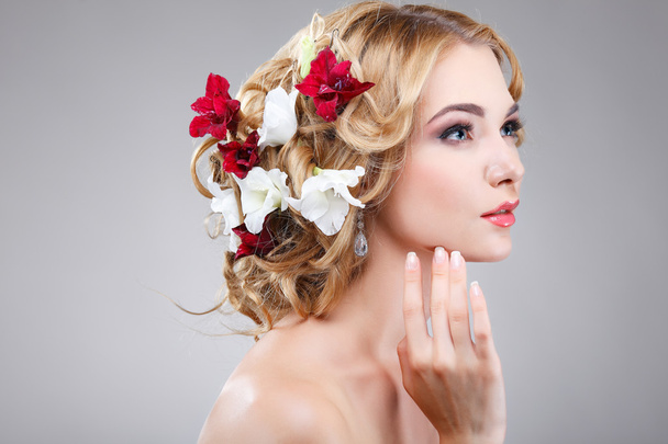 Beautiful  girl, isolated on a light - grey  background with varicoloured flowers  in hairs, emotions, cosmetics - Foto, immagini