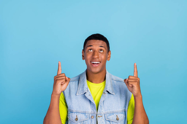 Photo of young african man look indicate fingers empty space promotion suggest isolated over blue color background - Foto, Imagen