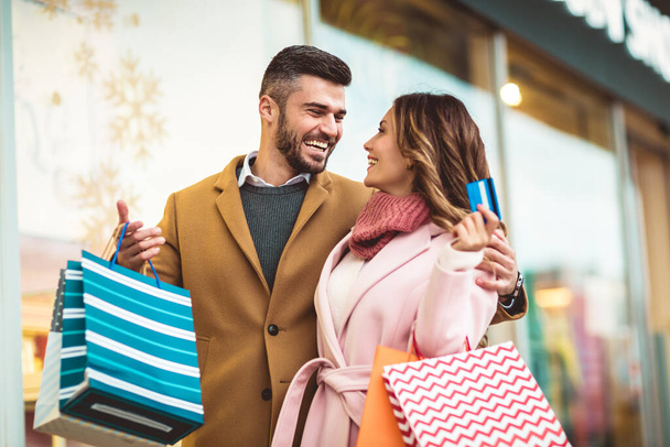 Hermosa pareja de compras con una tarjeta de crédito en la ciudad
 - Foto, Imagen