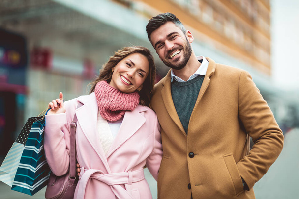 Porträt eines glücklichen Paares mit Einkaufstüten. - Foto, Bild