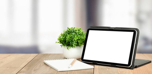 digitale tablet, plant, notitieboekje en pen op een houten tafel. defocus wazig achtergrond van home space - Foto, afbeelding