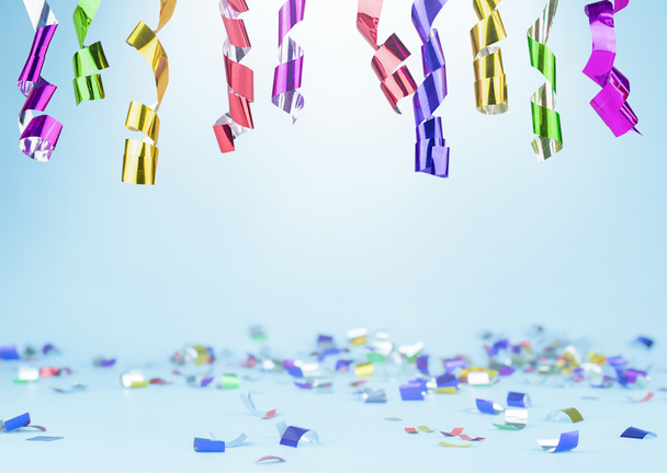 multi colored confetti and serpentine on a light blue background. background for celebration - Photo, Image