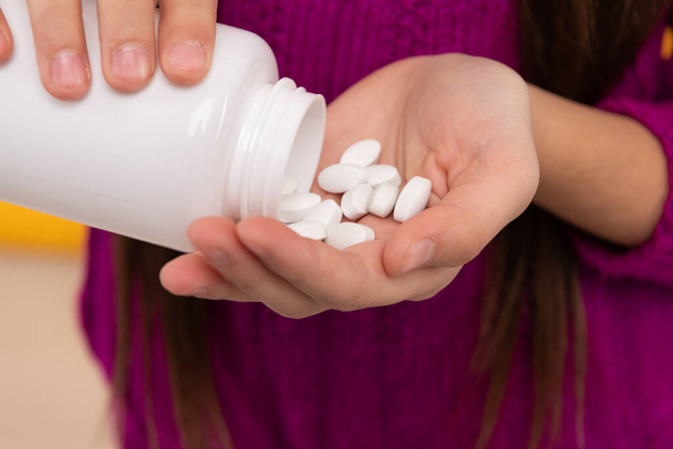 Tabletit oraaliseen käyttöön. Tabletit valuvat pullosta lasten käsiin. Reseptilääkkeet - Valokuva, kuva
